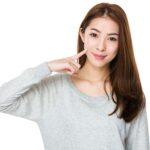 Woman pointing to her cheek dimple. Plastic surgery in Honolulu, Hawaii.