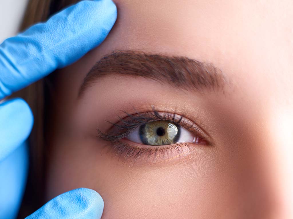 A Honolulu Asian double-eyelid plastic surgeon examines patient following an Asian blepharoplasty surgery, Oahu.