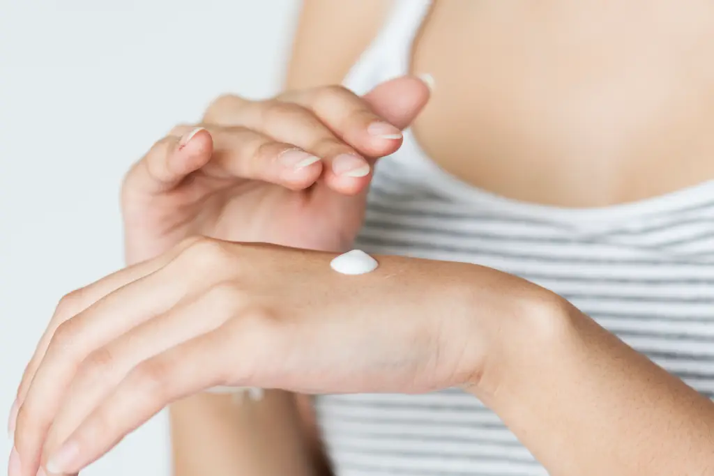 Woman applying sunscreen to her hand. Sunscreen helps prevent melasma in Honolulu Residents who are exposed to sunlight more than average