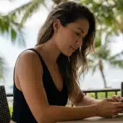 tech-neck-lift Hawaiian woman on phone searches for the difference between tech neck vs. turkey neck and how a deep plane neck lift or morpheus8 can help.